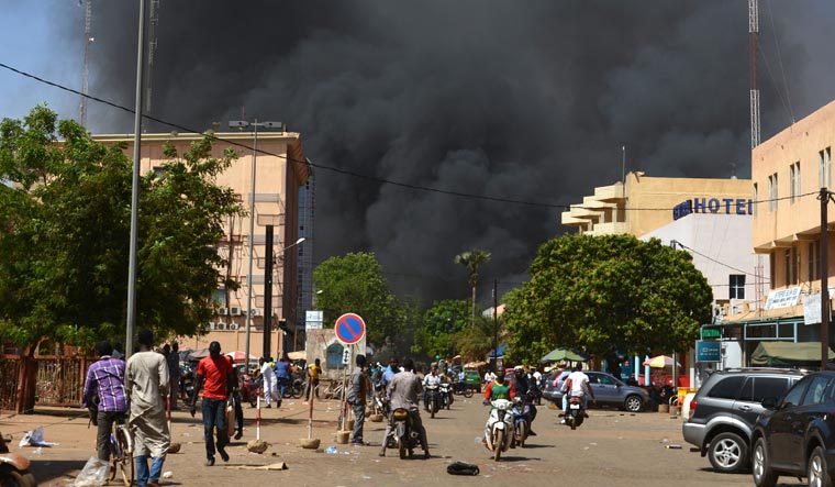 People watch as black smoke rises after the capital of Burkina Faso came under multiple attacks, targeting the French embassy, the French cultural centre and the country's military headquarters | AFP