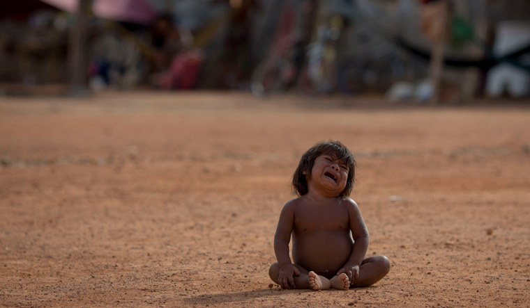 A Venezuelan indigenous refugee child cries at a shelter in the city of Boa Vista, Roraima, Brazil | AFP