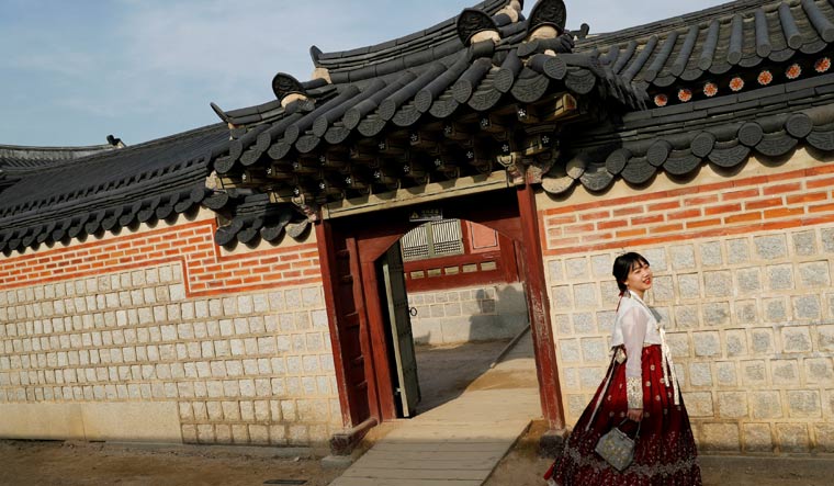 Tourists dressed in traditional Korean costumes visit the Gyeongbokgung Palace in Seoul, South Korea | Reuters
