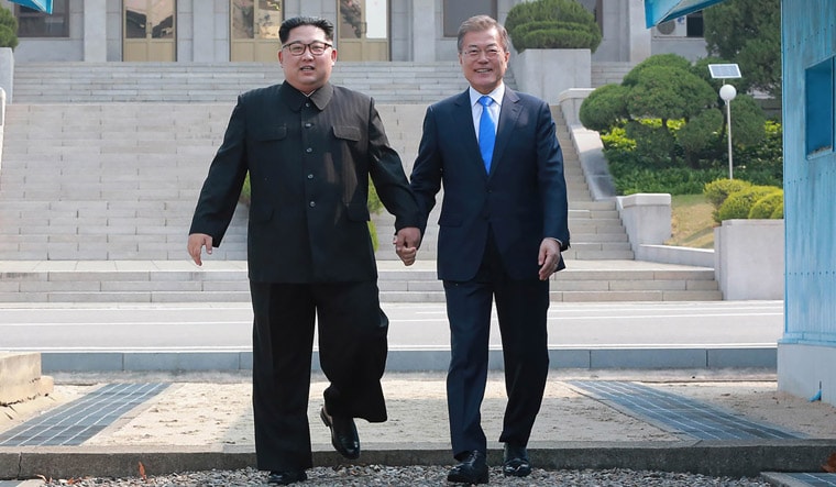 North Korea's leader Kim Jong Un (left) walking with South Korea's President Moon Jae-in (right) to the official summit Peace House building | AFP