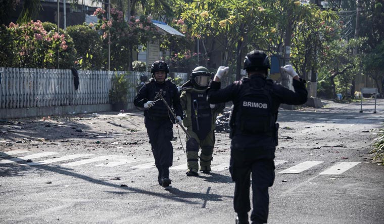 Indonesian bomb squad examines the site following a suicide bomb outside a church in Surabaya | AFP