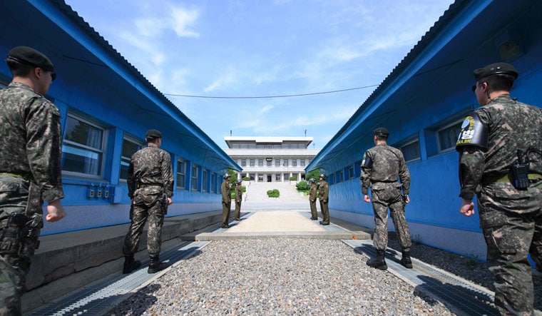 South Korean soldiers (front) and North Korean soldiers (rear) at  Panmunjeom in the Demilitarized zone | AFP