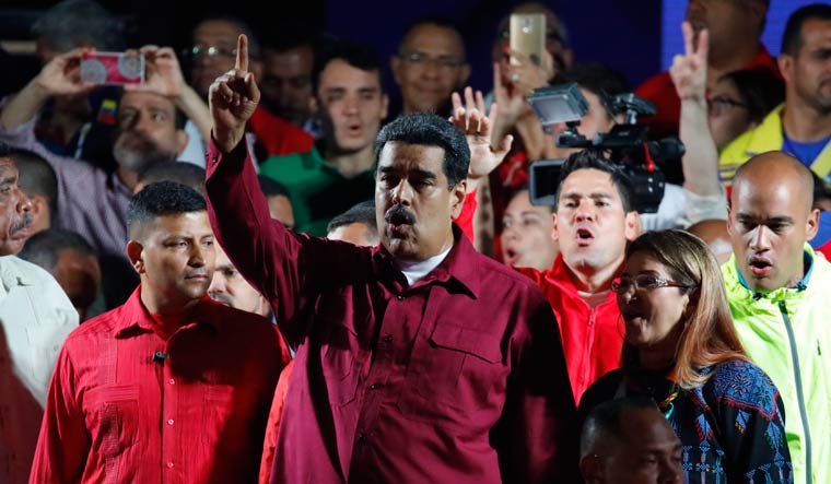 Venezuela's President Nicolas Maduro raises a finger as he is surrounded by supporters while speaking during a gathering after the results of the election were released, outside of the Miraflores Palace in Caracas, Venezuela | Reuters