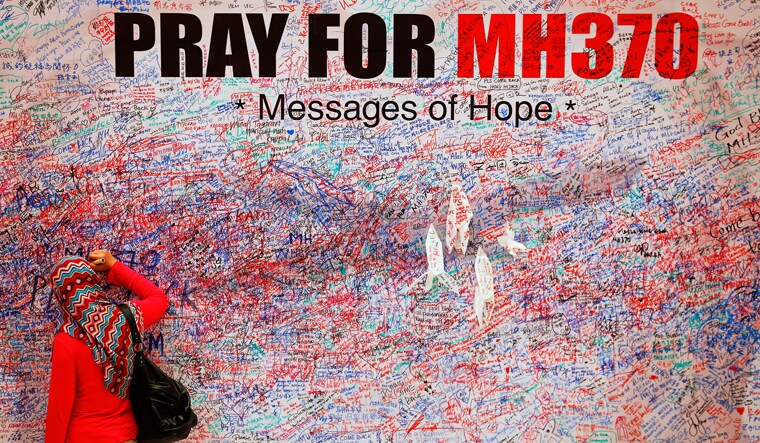 A woman leaves a message of support and hope for the passengers of the missing Malaysia Airlines MH370 in central Kuala Lumpur | Reuters