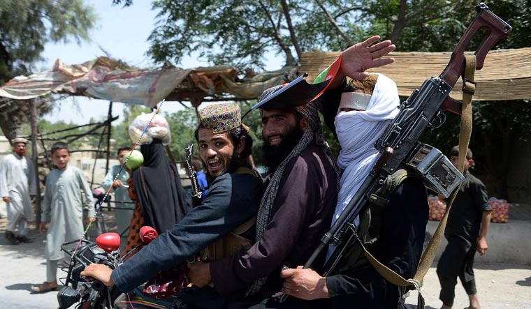 [FILE] Afghan Taliban militants ride a motorbike as they take to the streets to celebrate a ceasefire on the second day of Eid in the outskirts of Jalalabad on June 16 | AFP
