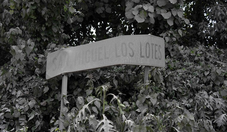 View of a roadside sign covered in ashes at San Miguel Los Lotes, a village in Escuintla Department, about 35 km southwest of Guatemala City, a day after the eruption of the Fuego Volcano | AFP