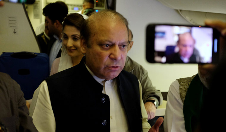 Pakistani Prime Minister Nawaz Sharif gestures as he boards a Lahore-bound flight due for departure, at Abu Dhabi International Airport | Reuters