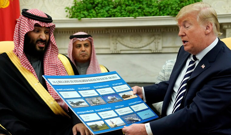 US President Donald Trump holds a chart of military hardware sales while meeting Saudi Arabia's Crown Prince Mohammed bin Salman in March | Reuters