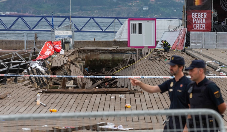 Two police officers walk at the scene the day after an oceanside boardwalk collapsed, in Vigo, Spain | AP