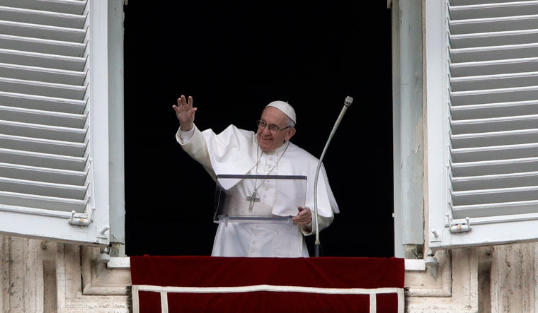 Pope Francis salutes the crowd as he recites the Angelus noon prayer from the window of his studio overlooking St.Peter's Square, at the Vatican | AP