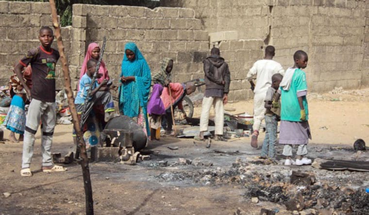 People pack the rest of their belongings following an attack, at the Sajeri village, on the outskirts of the Borno state capital, Maiduguri | AFP