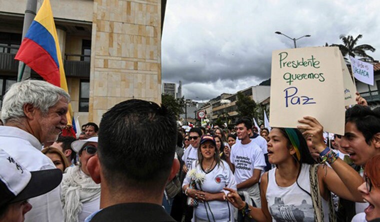 A woman shouts at Bogota's Mayor Enrique Penaloza (L), during a demonstration at Bolivar square in Bogota, against terrorism, in repudiation of the police academy recent car bombing and in support of the victims and their relatives | AFP