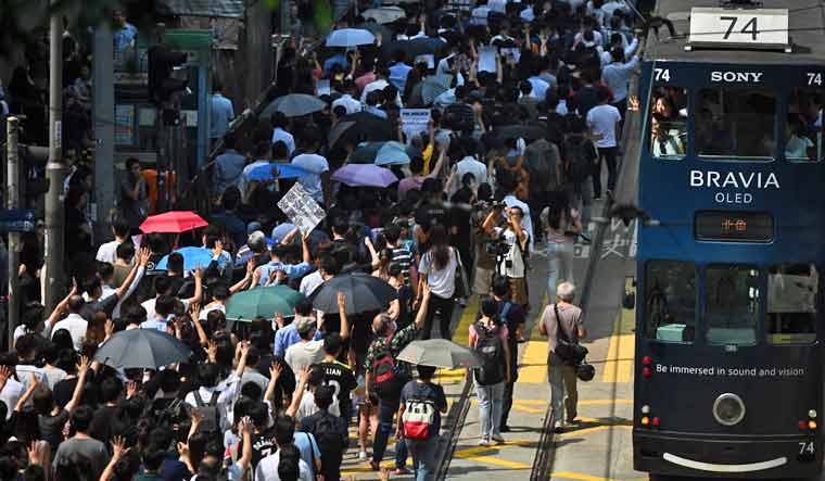 People attend a flash mob rally to show support for pro-democracy protesters in the Central district in Hong Kong | AFP