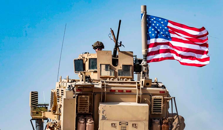 File photo of US troops atop an armoured vehicle near the Syrian border rown of Ras al-Ayn | AFP 