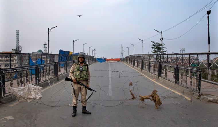 In this Friday, Sept. 27, 2019, file photo, an Indian paramilitary force soldier stands guard near a barbwire barricade during restrictions in Srinagar, Indian controlled Kashmir | AP