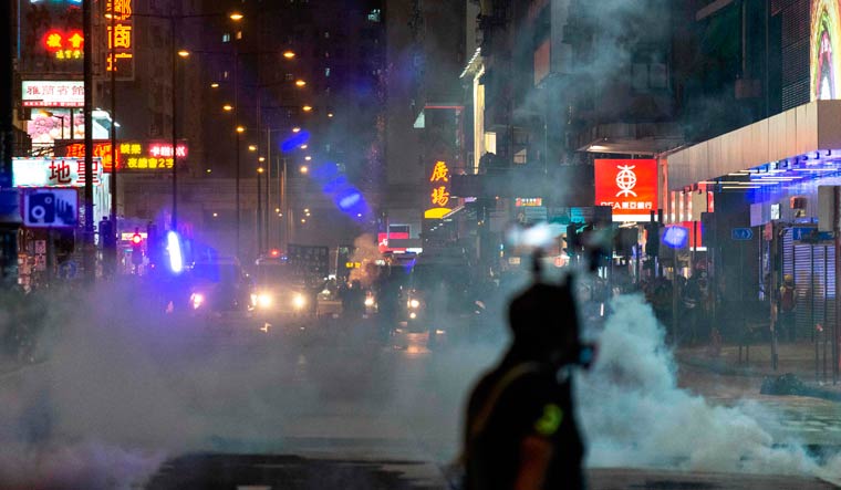 Police fire tear gas to disperse bystanders after a rally in the Mong Kok district in Hong Kong on October 27, 2019 | AFP