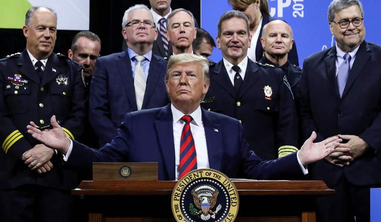 U.S. President Donald Trump reacts after signing an executive order during an appearance at the International Association of Chiefs of Police annual conference and expo in Chicago | Reuters