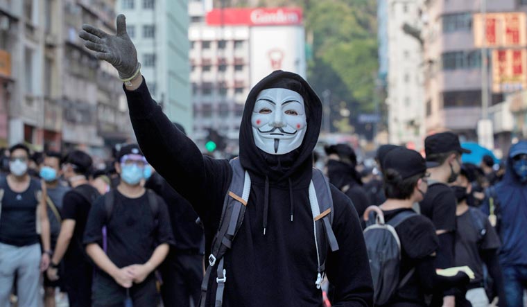 An anti-government protester wearing a Guy Fawkes mask | Reuters