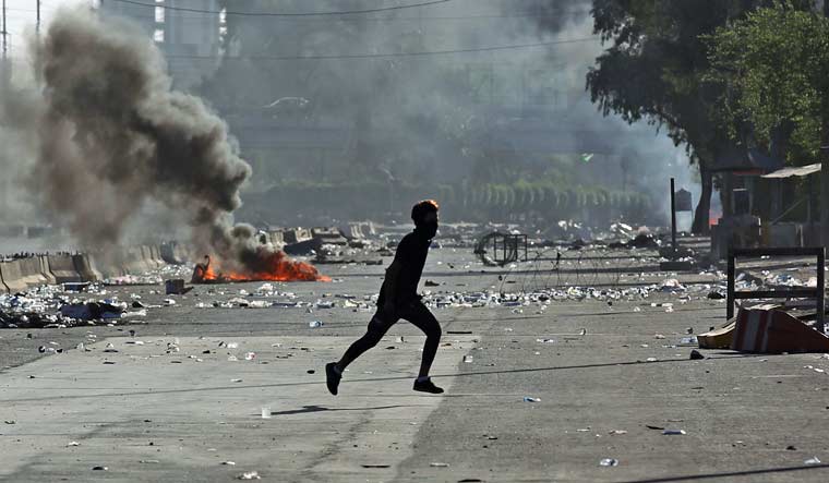 An Iraqi protester runs amidst clashes at Iraqi capital Baghdad's central Khellani Square | AFP
