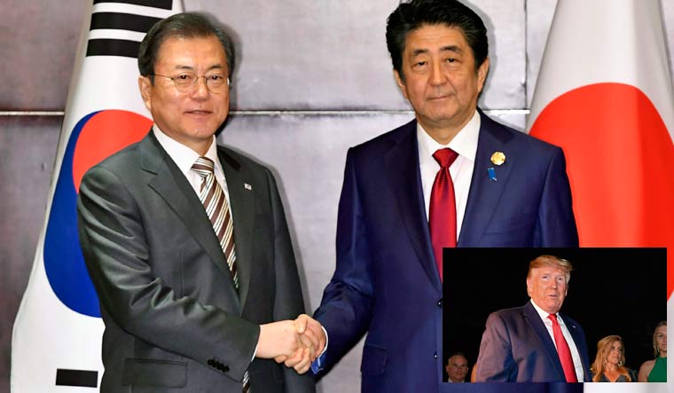 South Korean President Moon Jae-in, left, shakes hands with Japanese Prime Minister Shinzo Abe | AP; inset: US President Donald Trump | AFP