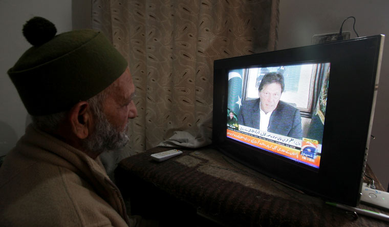 A man watches the speech of  Pakistani Prime Minister Imran Khan on TV, in Lahore | Reuters