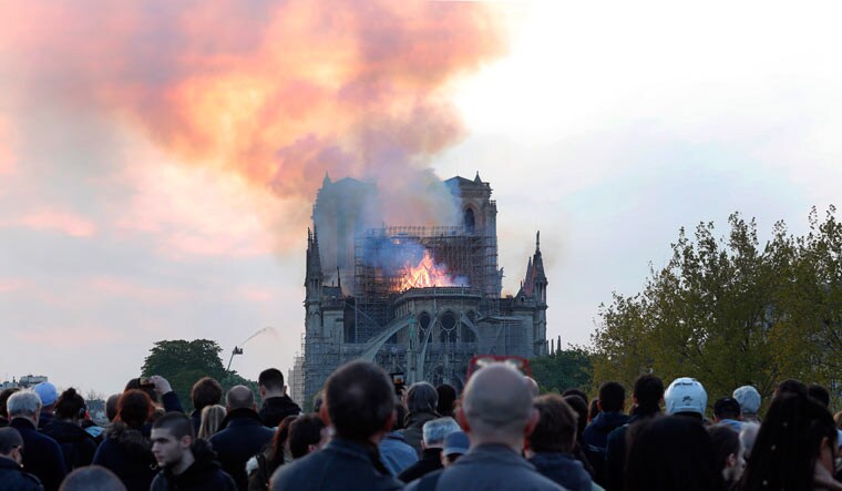 People watch as flames and smoke rise from Notre-Dame Cathedral in Paris | AP