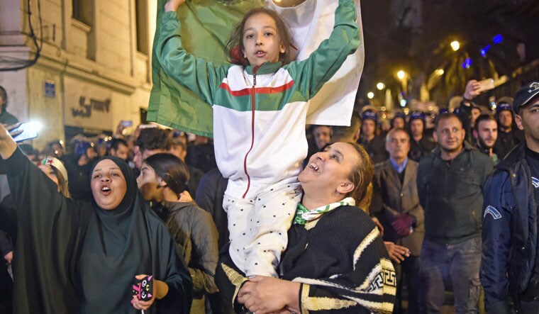 Algerians celebrate after Algeria's veteran President Abdelaziz Bouteflika informed the Constitutional Council that he is resigning | AFP