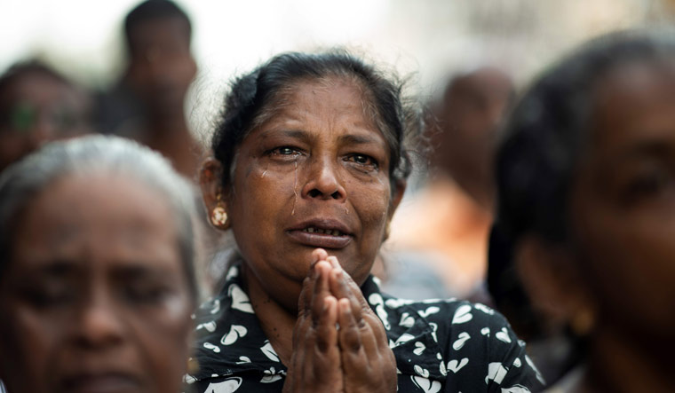 A woman cries as she prays at a barricade near St Anthony's Shrine in Colombo on April 28, a week after a series of bomb blasts targeting churches and luxury hotels on Easter Sunday in Sri Lanka | AFP