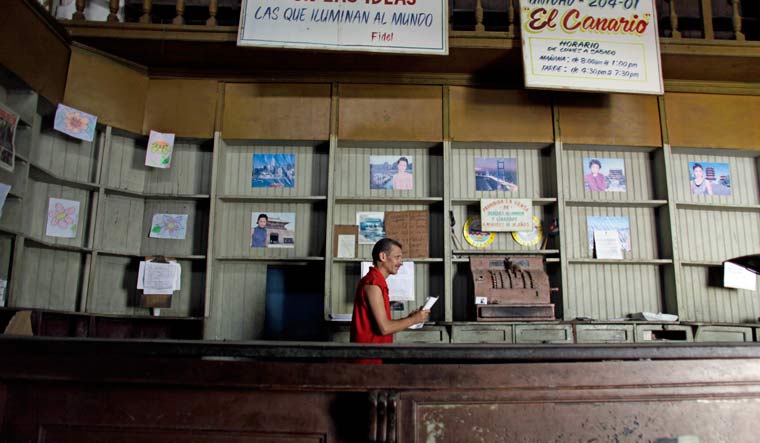 An employee works in a government food store with empty shelves in Havana, Cuba | AP