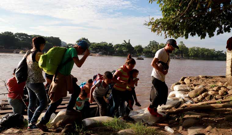 Migrants and residents use a makeshift raft to illegally cross the Suchiate river, from Tecun Uman, in Guatemala to Ciudad Hidalgo, Chiapas state, Mexico | AFP