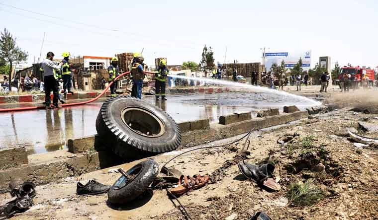 File photo: Firefighters clear the debris after an attack on a NATO convoy in Kabul on MAy 31 | AFP