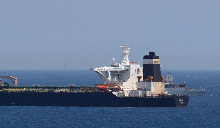 A British Royal Navy ship (back R) patrols near supertanker Grace 1 suspected of carrying crude oil to Syria in violation of EU sanctions after it was detained off the coast of Gibraltar | AFP