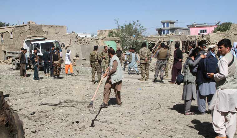 Afghan security forces inspect the site of a car bomb attack in Ghazni province, central Afghanistan | AP