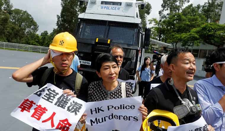 Claudia Mo and fellow pro-democracy lawmakers attend a demonstration of a water cannon equipped vehicle at the compound of the Police Tactical Unit in Hong Kong | Reuters
