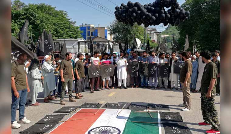 People carry black flags and balloons in Muzaffarabad, Pakistan to observe Black Day on August 15, India's Independence Day | Reuters