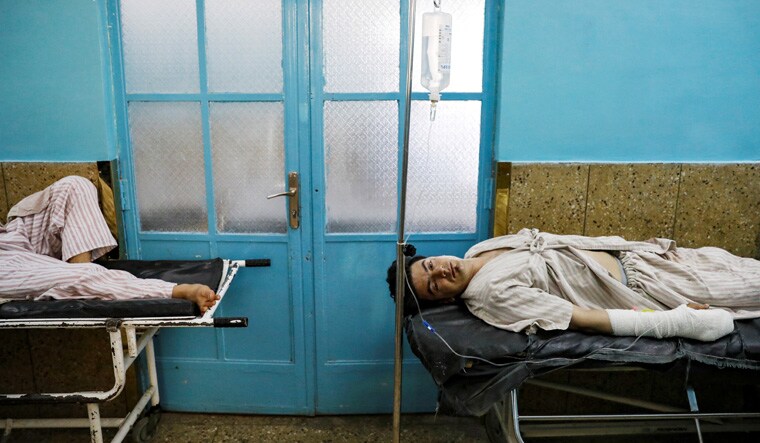 Injured men receive treatment in the hospital after sustaining wounds from a blast at a wedding hall in Kabul, Afghanistan | Reuters