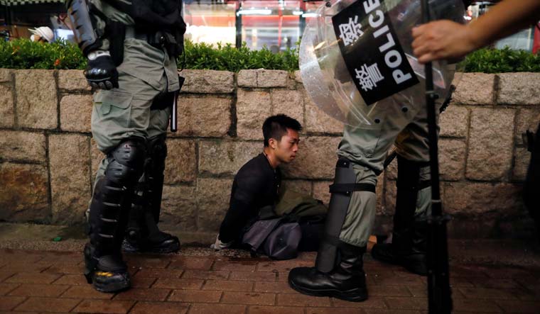 File photo : Two riot policemen detain a protester in Hong Kong | Reuters