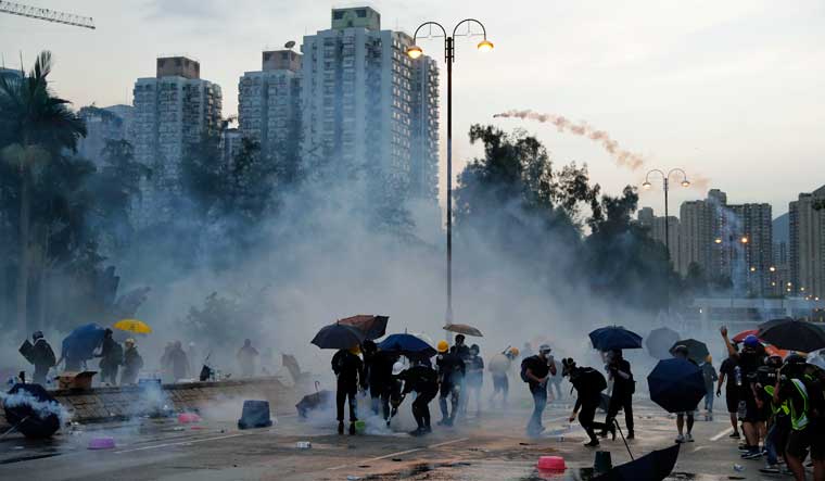 Protesters throw back tear gas canisters in Hong Kong on Monday | AP
