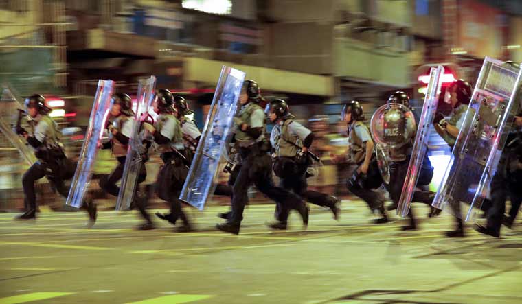 Policemen in riot gears move to disperse residents and protesters at Sham Shui Po district in Hong Kong | AP