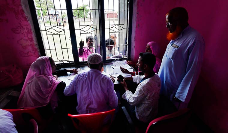 People check their names on the final list of the National Register of Citizens (NRC) in an office in Pavakati village of Morigoan district | AFP