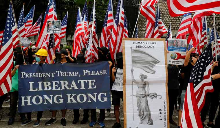 [File] Protesters march to the United States embassy waving US flags during a demonstration in Hong Kong | Reuters