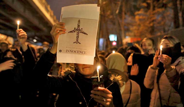 File: People gather for a candlelight vigil to remember the victims of the Ukraine plane crash, at the gate of Amri Kabir University | AP