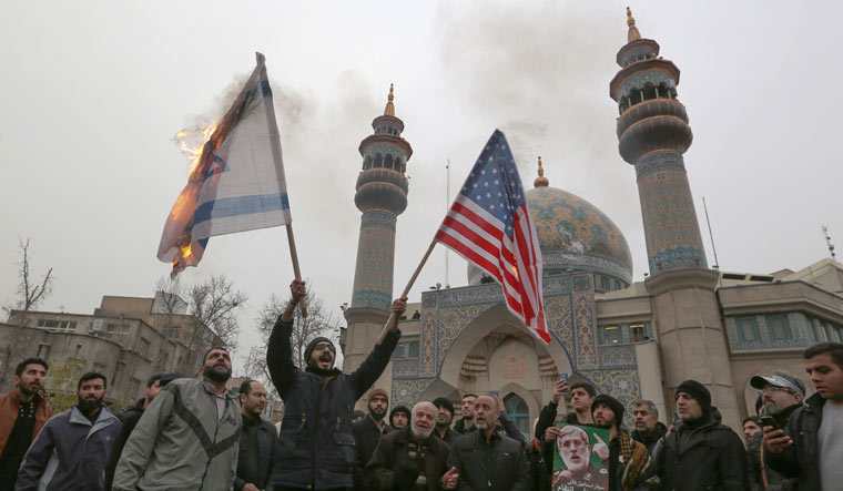 Iranians burn an Israeli and a US flag during an anti-US protest in Tehran | AFP
