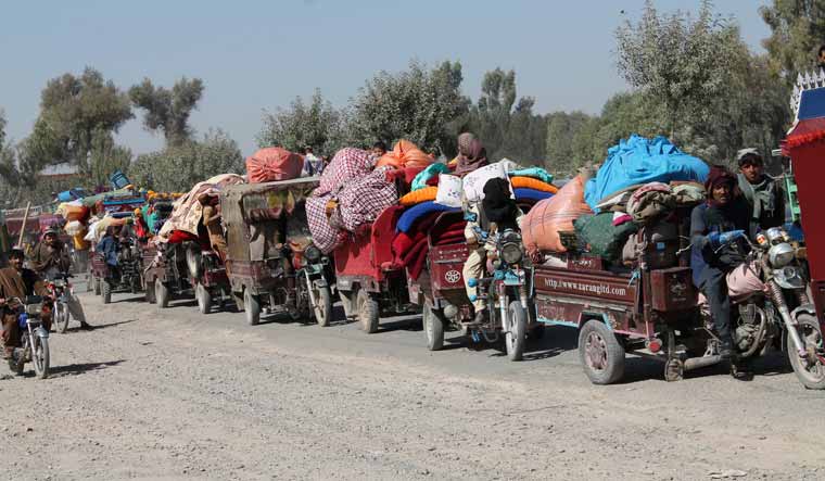 Afghan families leave their houses after fighting between the Afghan military and Taliban insurgents in Helmand province, southern of Afghanistan, Tuesday, Oct. 13, 2020. (AP Photo/Abdul Khaliq)
