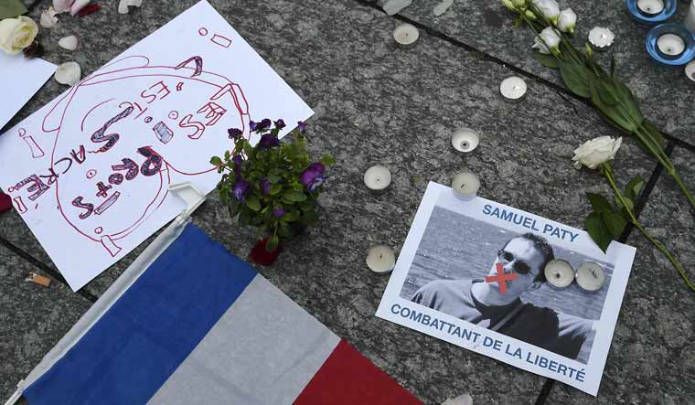 A photo shows a placard with the portrait of history teacher Samuel Paty and reading "Freedom fighter" as people gather in Strasbourg, eastern France, in a show of solidarity and defiance | AFP