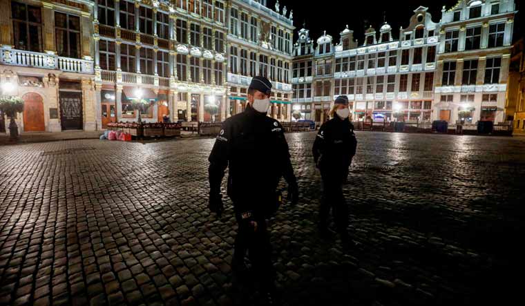 Police officers wearing protective face masks patrol at the start of the curfew in Brussels | AFP