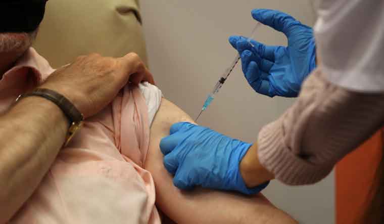 A medical worker vaccinates a man against the coronavirus disease (COVID-19) | Reuters 