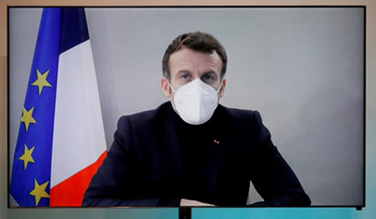 FILE PHOTO: French President Emmanuel Macron, tested positive for the coronavirus disease (COVID-19), is seen on a screen as he attends by video conference a round table for the National Humanitarian Conference (NHC) at the Foreign Affairs Ministry in Paris, France, December 17, 2020 | REUTERS/Charles Platiau/Pool/File Photo
