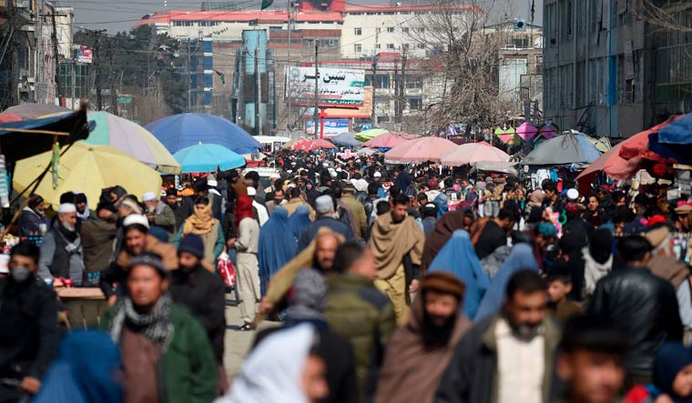 Pedestrians walk through a crowded market in Kabul | AFP
