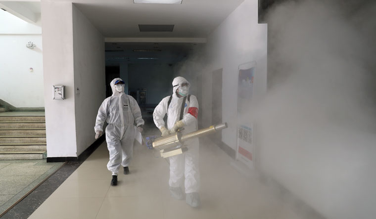 Volunteers in protective suits disinfect a residential compound in Wuhan, the epicentre of the novel coronavirus outbreak, in Hubei province, China | Reuters